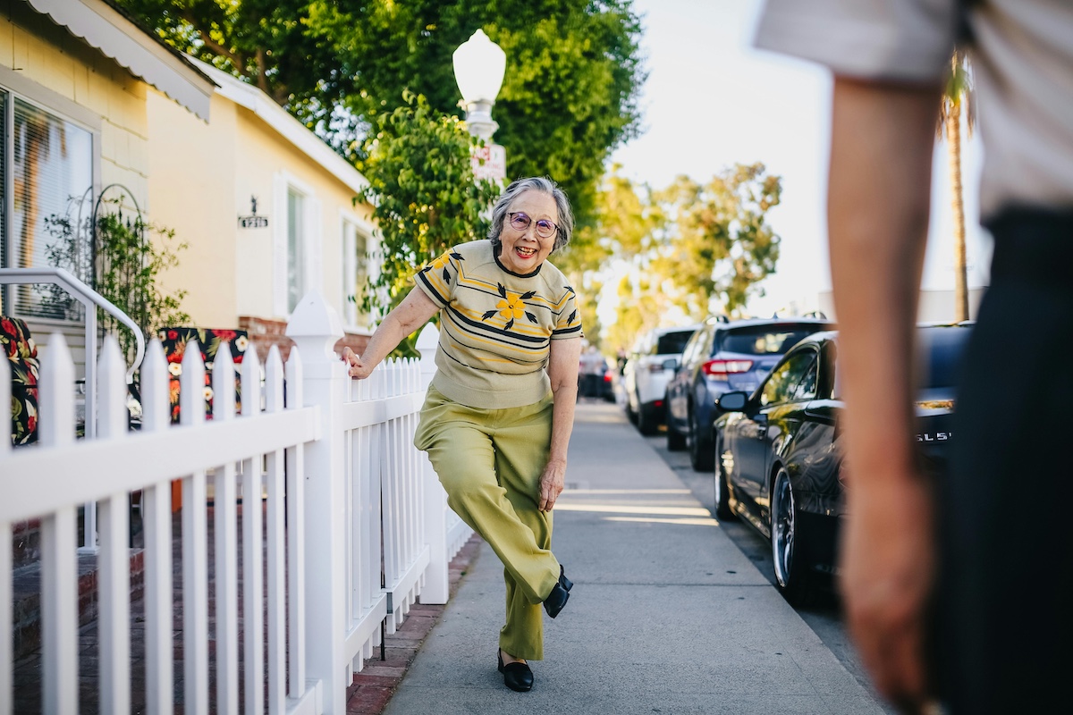 Elderly lady walking in neighborhood.