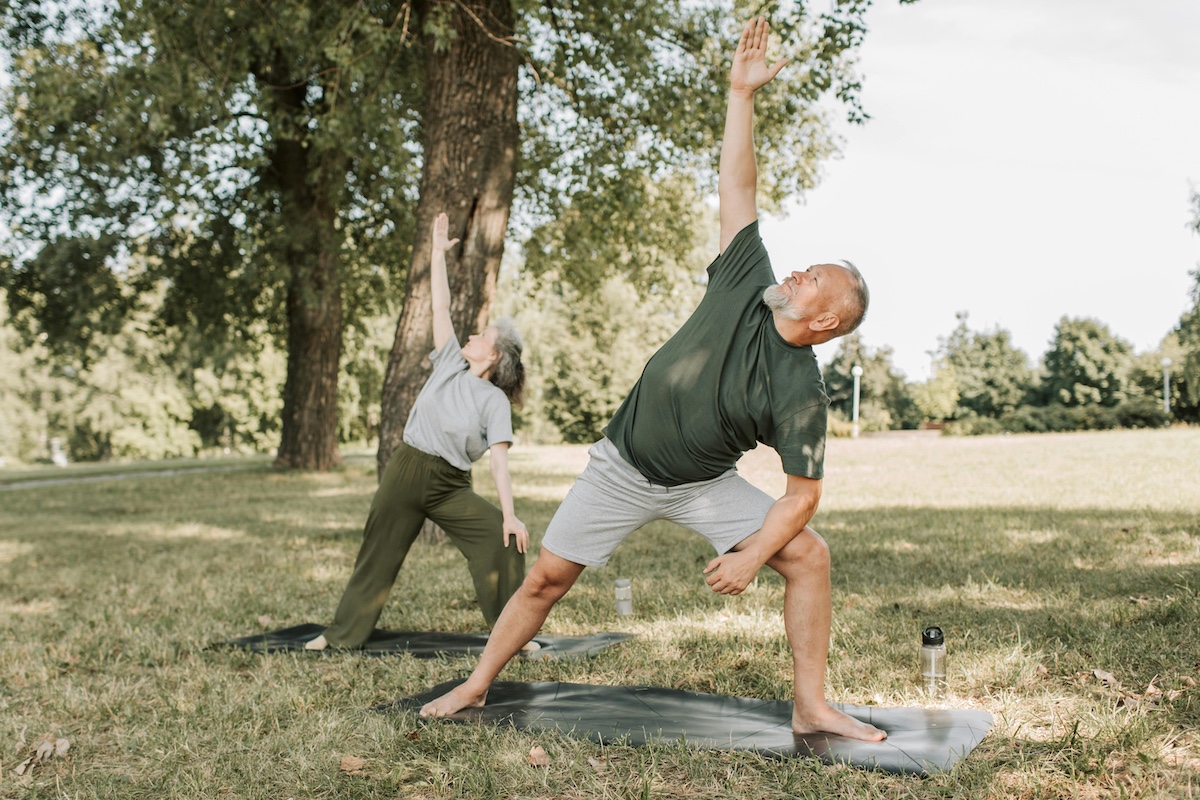 Older couple practicing yoga outdoors in Welaka, Florida.