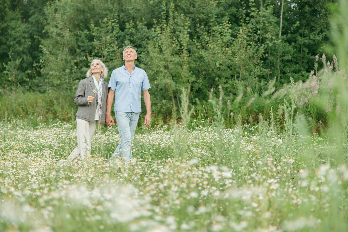 Older couple holding hands while walking through a local park in Palatka, Florida.