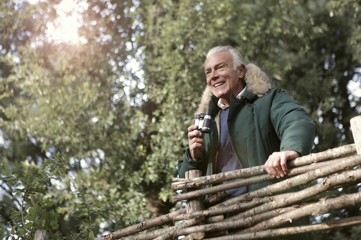 Old man with binoculars waiting for his favorite bird.